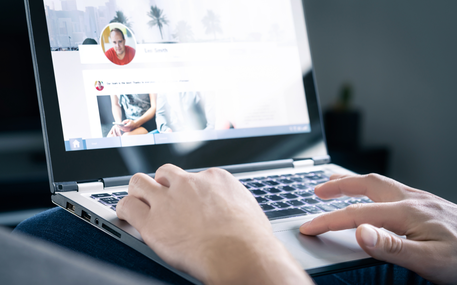 Laptop computer with person hands scrolling social media.