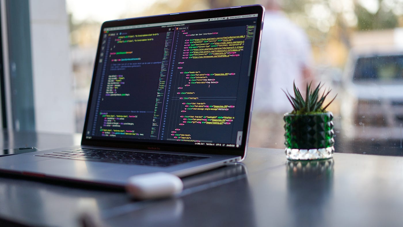 MacBook Pro with AI/ML Code on screen.